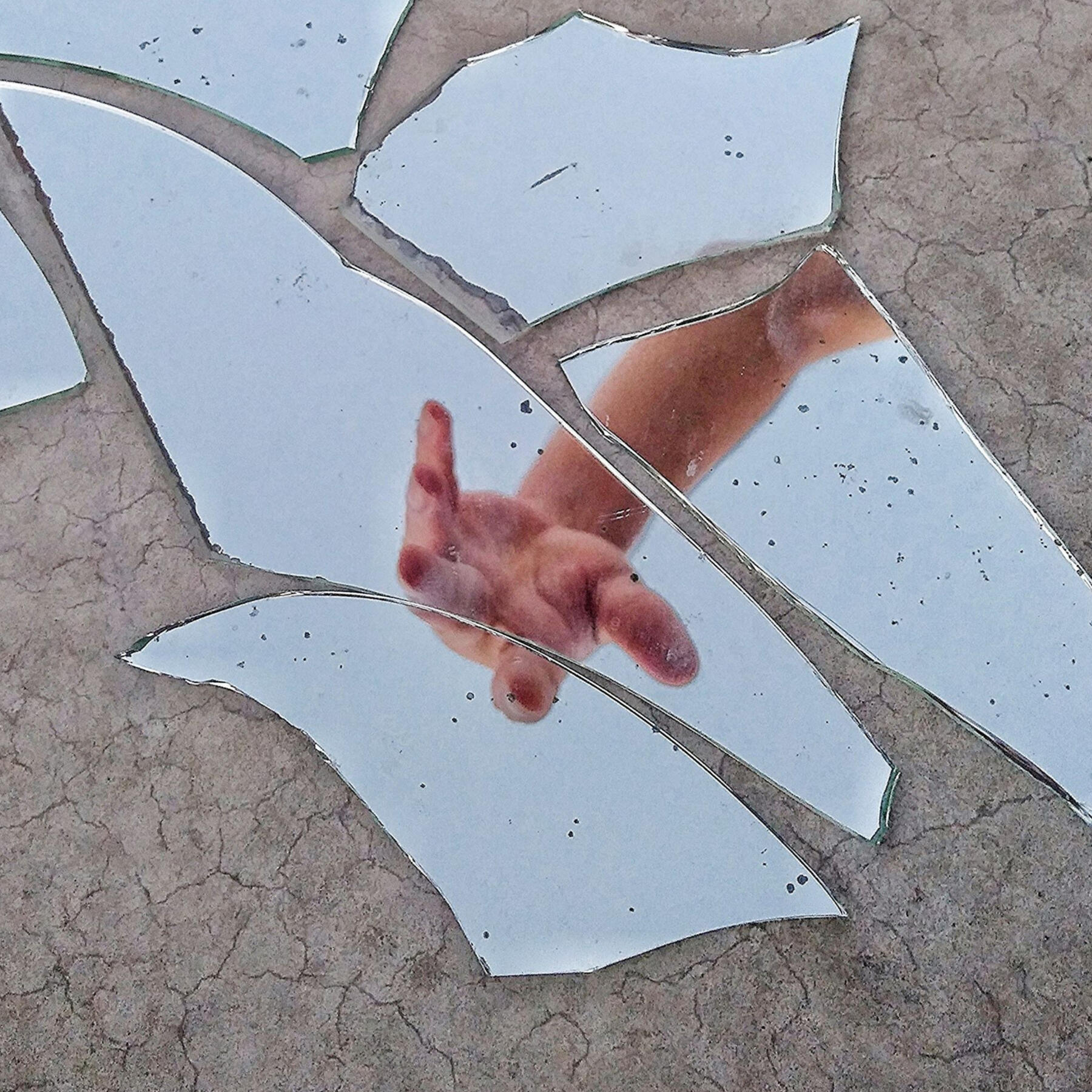 Photo by Thiago Matos from Pexels: https://www.pexels.com/photo/mirror-fragments-on-gray-surface-with-the-reflection-of-a-person-s-hand-3022456/